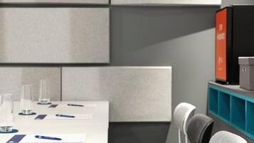 A conference room with a white table, chairs, and a blue storage unit.