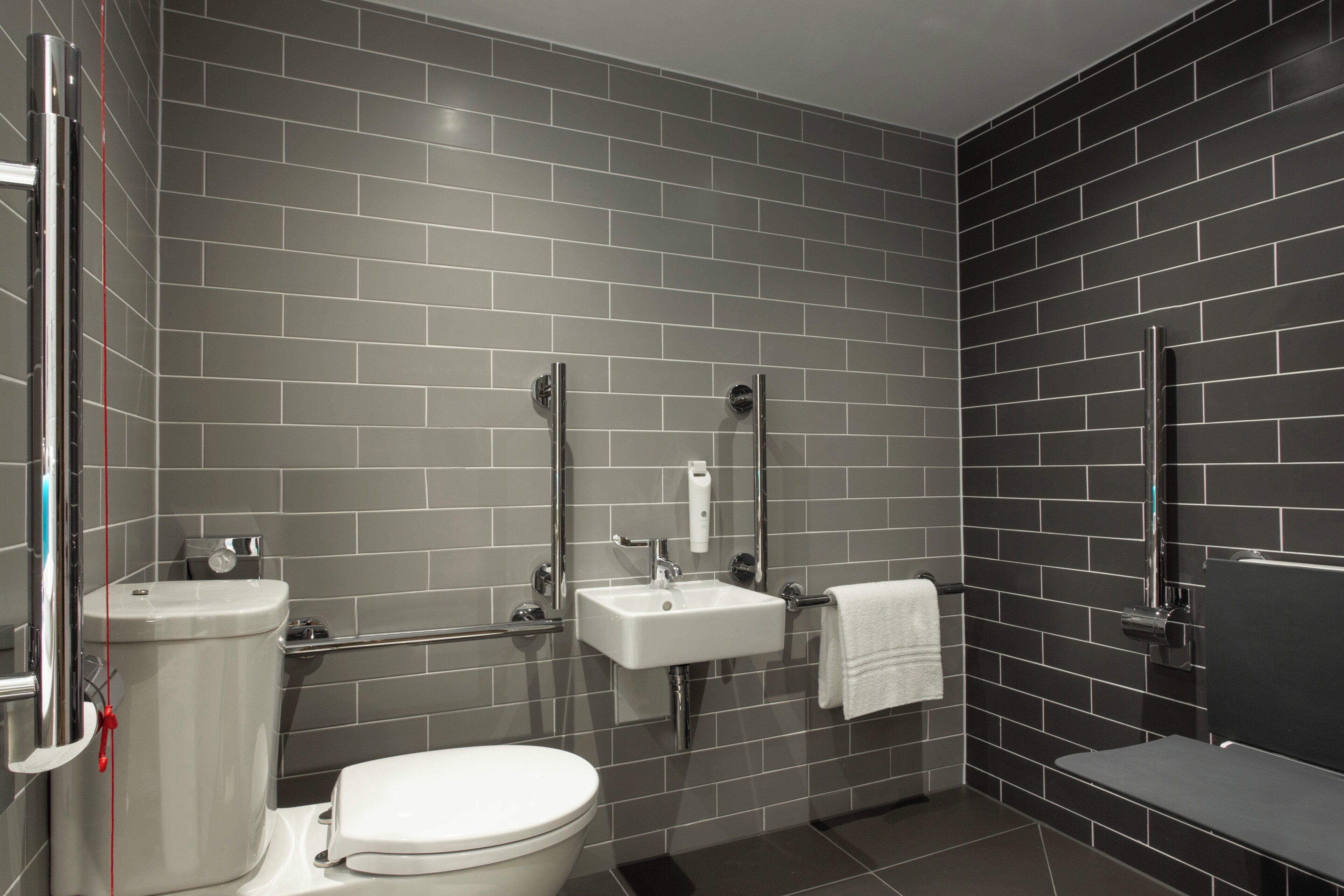 Een moderne badkamer met toilet, wastafel en douche.