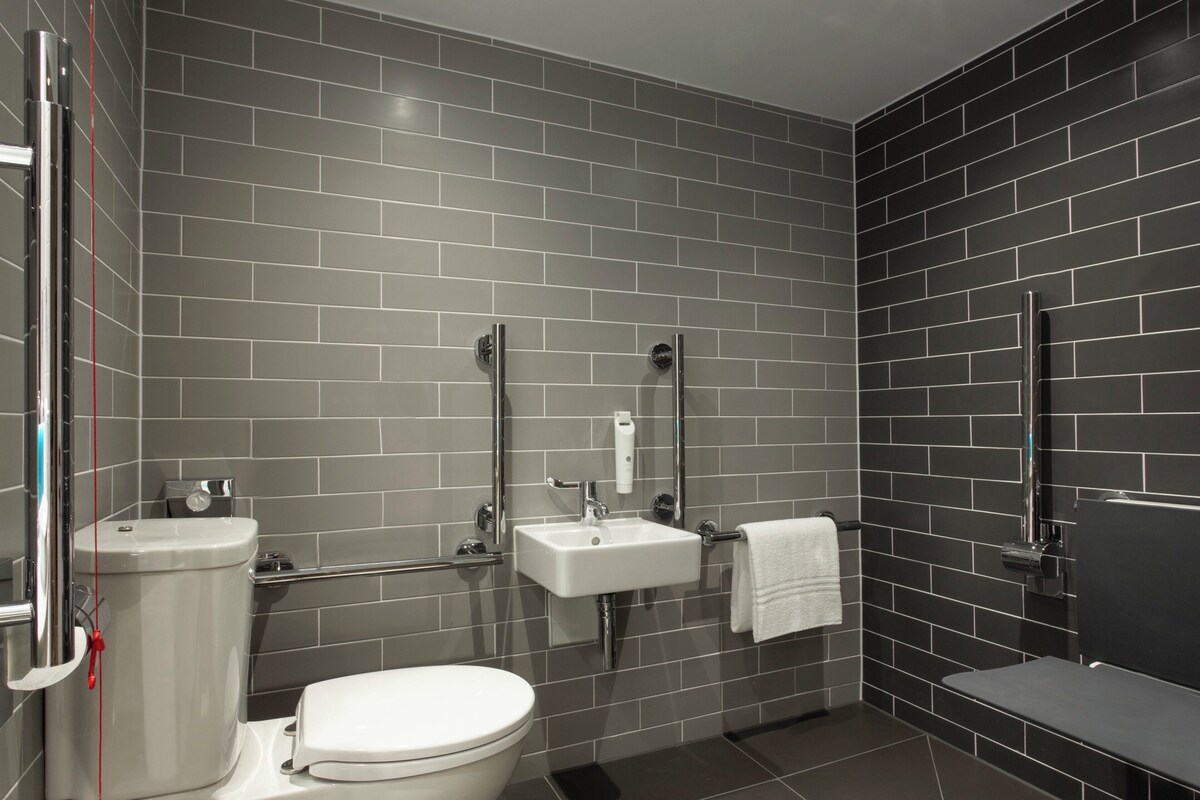 A modern bathroom with a toilet, sink, and shower area.