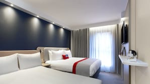 A hotel room with two beds, a flat-screen TV, a bedside table, and a window with curtains. - Holiday Inn Express Barrow-in-Furness by IHG (Barrow-in-Furness)