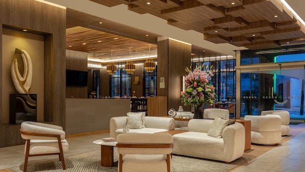 A modern lobby with a reception desk, seating area, and large windows. - Holiday Inn Lima Miraflores by IHG (Lima)