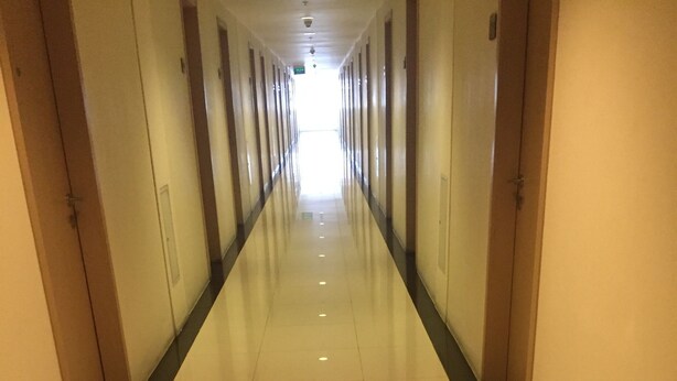 A long, narrow hotel corridor with a shiny tiled floor and doors on both sides. - Staycation at smdc grass residences (Quezon city)