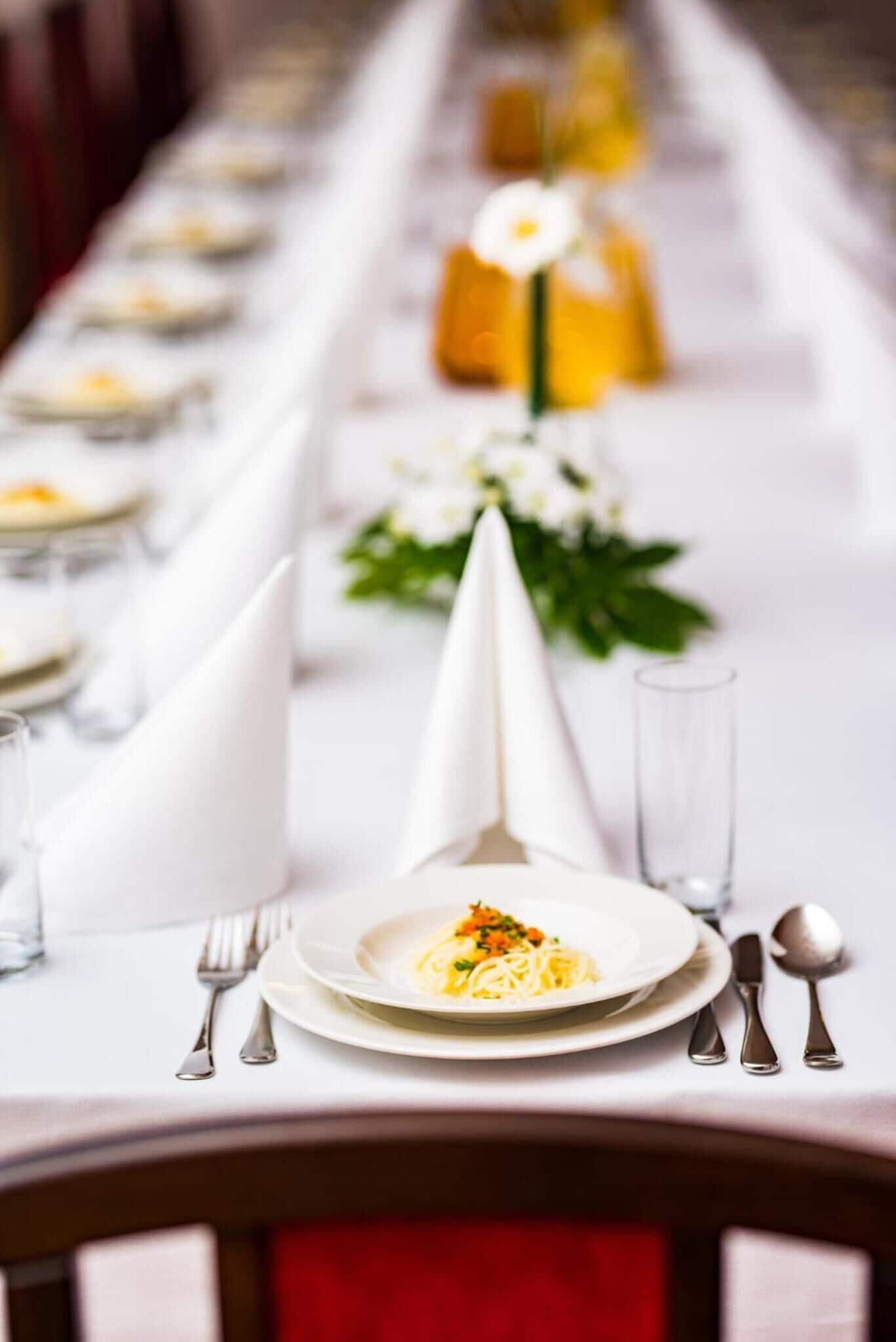 Une table à manger dressée avec des assiettes, des couverts et des serviettes.