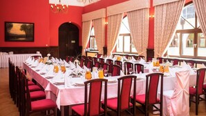 A banquet hall with long tables set for dining, red chairs, and large windows with curtains. - Oficyna przy Pałacu Krobielowice (Katy Wroclawskie)