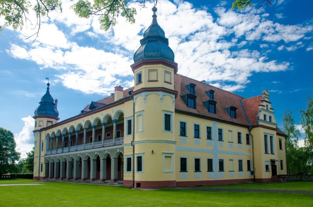 A large, historic building with multiple towers and a central courtyard.