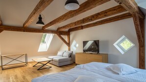 A bedroom with a bed, a sofa, a TV, and a desk. - Oficyna przy Pałacu Krobielowice (Katy Wroclawskie)
