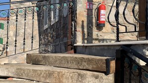 Un edificio de piedra con un extintor colgado en la pared.