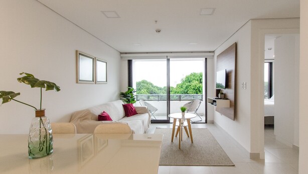 A modern living room with a sofa, a coffee table, and a TV mounted on the wall. - Barrio Jara's Best Choice (Asunción)