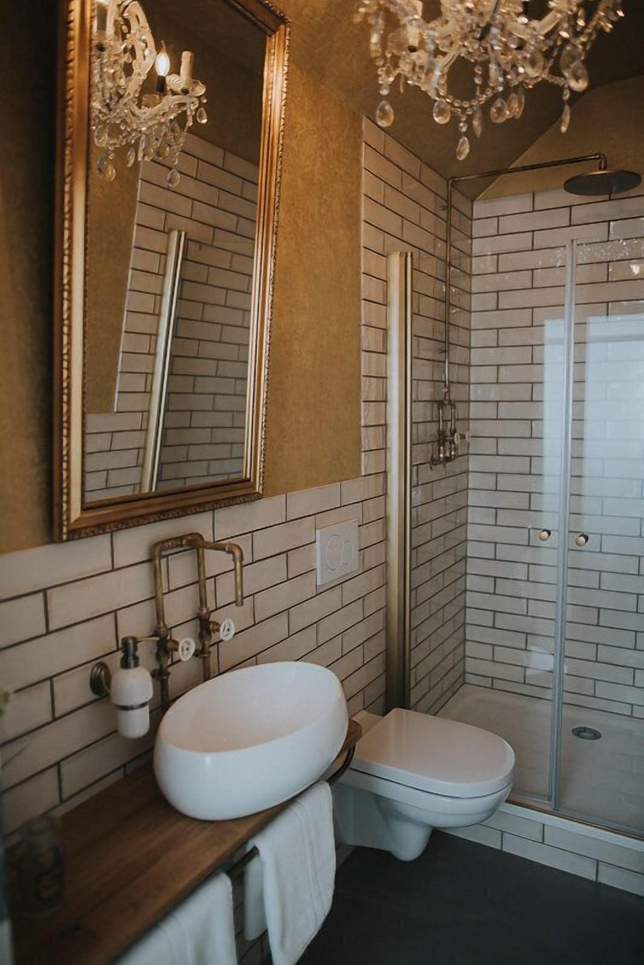 Ein Badezimmer mit weißem Waschbecken, Toilette und einer Duschkabine aus Glas.