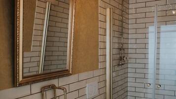 Ein Badezimmer mit weißem Waschbecken, Toilette und einer Duschkabine aus Glas.