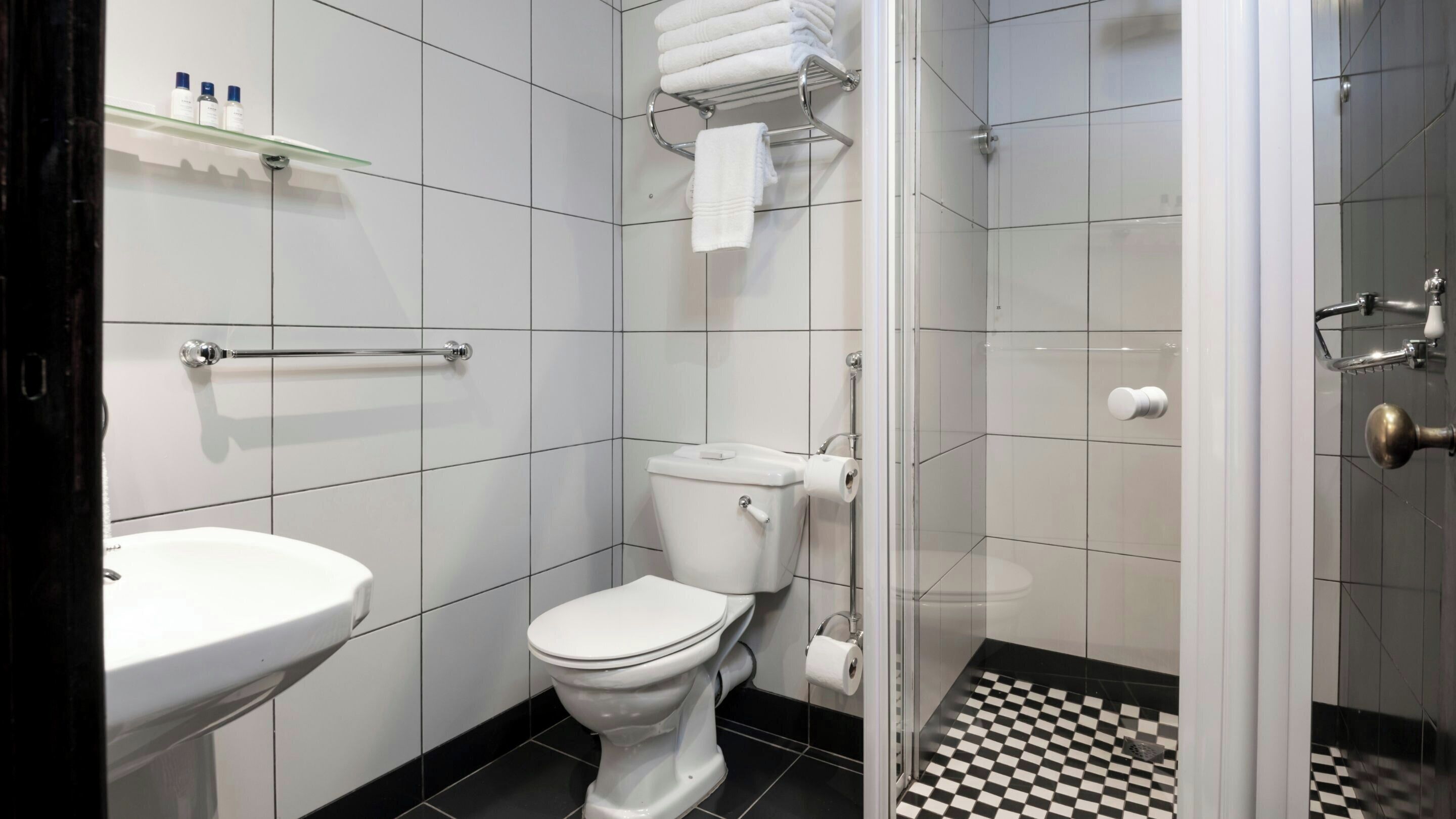 A bathroom with a toilet, sink, and shower.