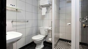 A bathroom with a toilet, sink, and shower.