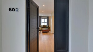 A hallway leading to a living room with a sofa and a coffee table. - ANEW Hotel Hilton (Pietermartizburg)