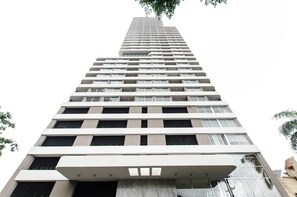 Un immeuble de grande hauteur doté d’une architecture moderne, avec de nombreux balcons et de grandes fenêtres.
