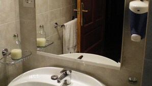 Ein Badezimmer mit Waschbecken, Spiegel und Tür.