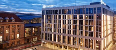 A modern building with a prominent "Hyperion" sign, surrounded by a parking area with bicycles and a few cars.