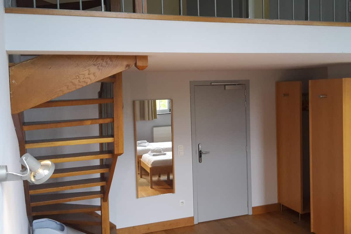 A room with a wooden staircase, a door, and a wardrobe.