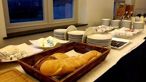 A buffet setup with various food items and plates. - Irish College Leuven (Leuven)
