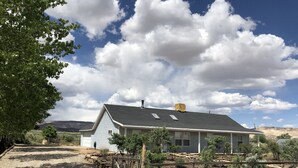 A single-story house with a gabled roof, a chimney, and a covered porch area. - Your Home Away From Home in Escalante (Escalante)