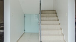 A staircase with a glass door at the bottom leading to a dark room. - Trendy Barrio Jara apartment (Asunción)