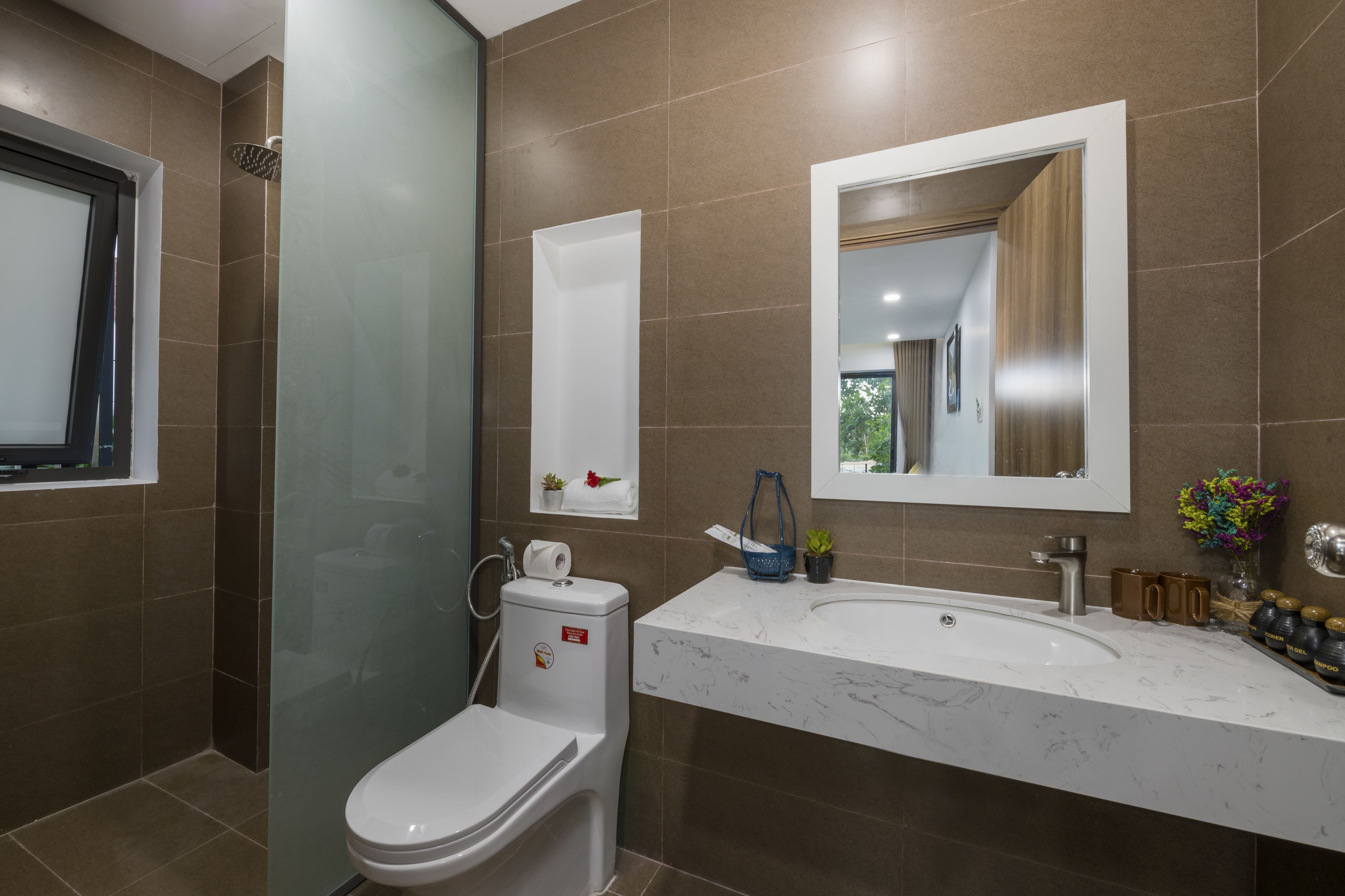 A modern bathroom with a toilet, shower, and sink.