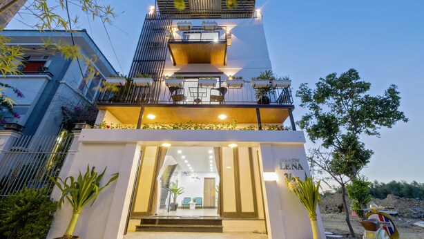 A modern hotel with a two-story structure, a balcony with outdoor seating, and a staircase leading to the entrance. - Lena Homestay (Da Nang)