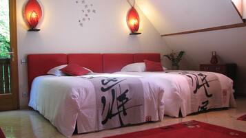 A bedroom with a red headboard, a bed with white bedding and red pillows, two wall-mounted red lamps, and a wall with Chinese characters.