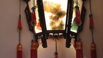 A wall-mounted decorative piece with a mirror and tassels.