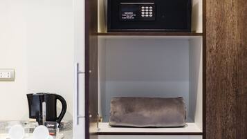 Una cocina con cafetera, microondas y una toalla en un estante.
