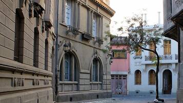 A narrow street with historic buildings, featuring arched windows and balconies.