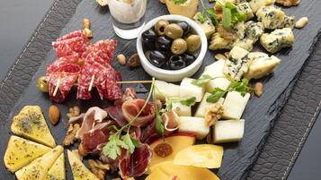 A charcuterie board with various cheeses, meats, nuts, and olives.