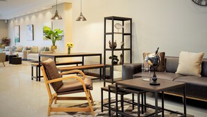 Una sala de estar moderna con un sofá, sillones, una mesa de centro, una estantería y un globo terráqueo.