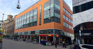 Un edificio moderno con grandes ventanales y un escaparate con el logotipo de Starbucks Coffee.