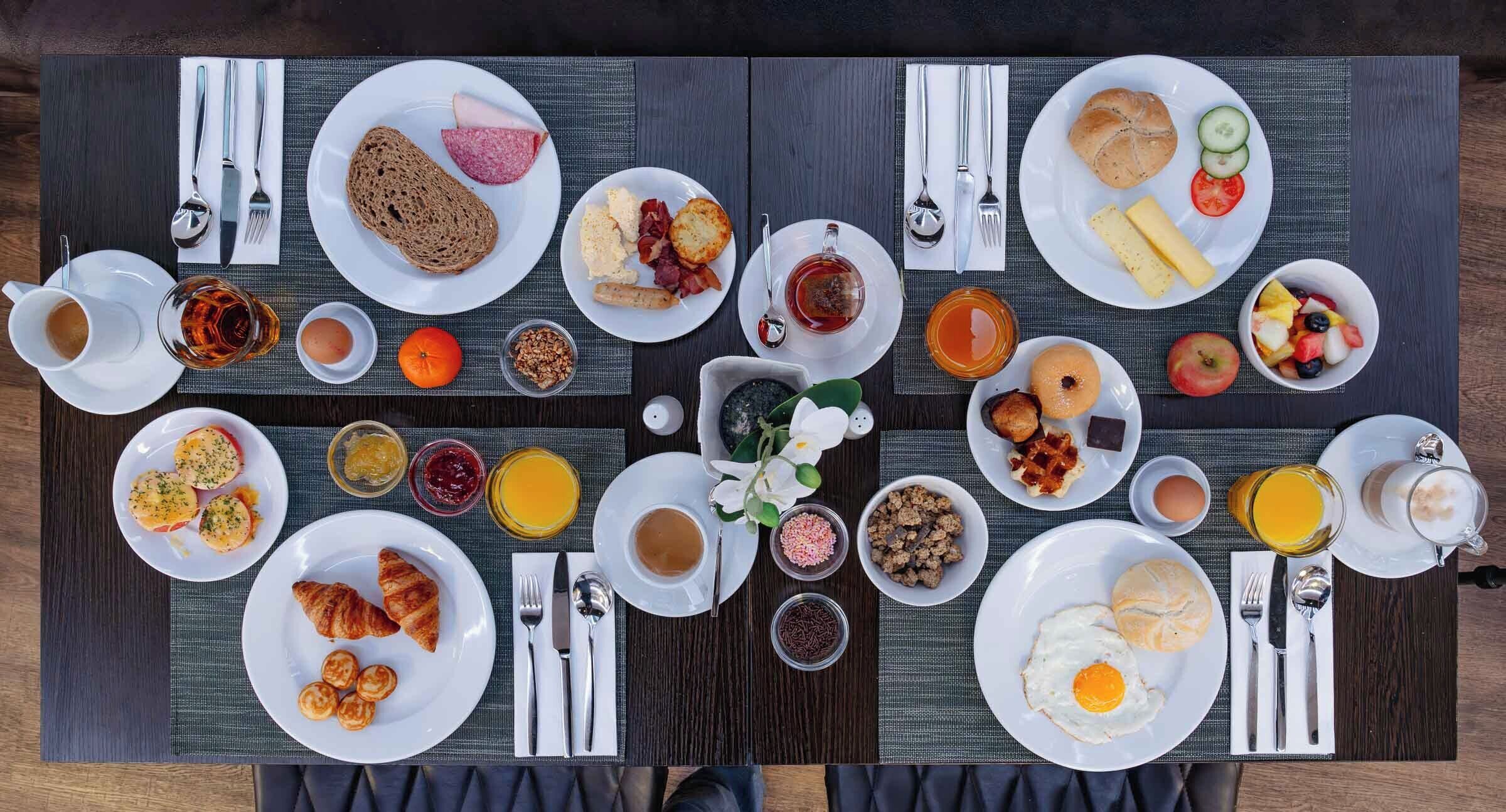 A breakfast buffet with various dishes and beverages.