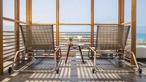 A wooden pergola structure with two lounge chairs facing a view of the sea. - The G Hotel Seashell (El Alamein)