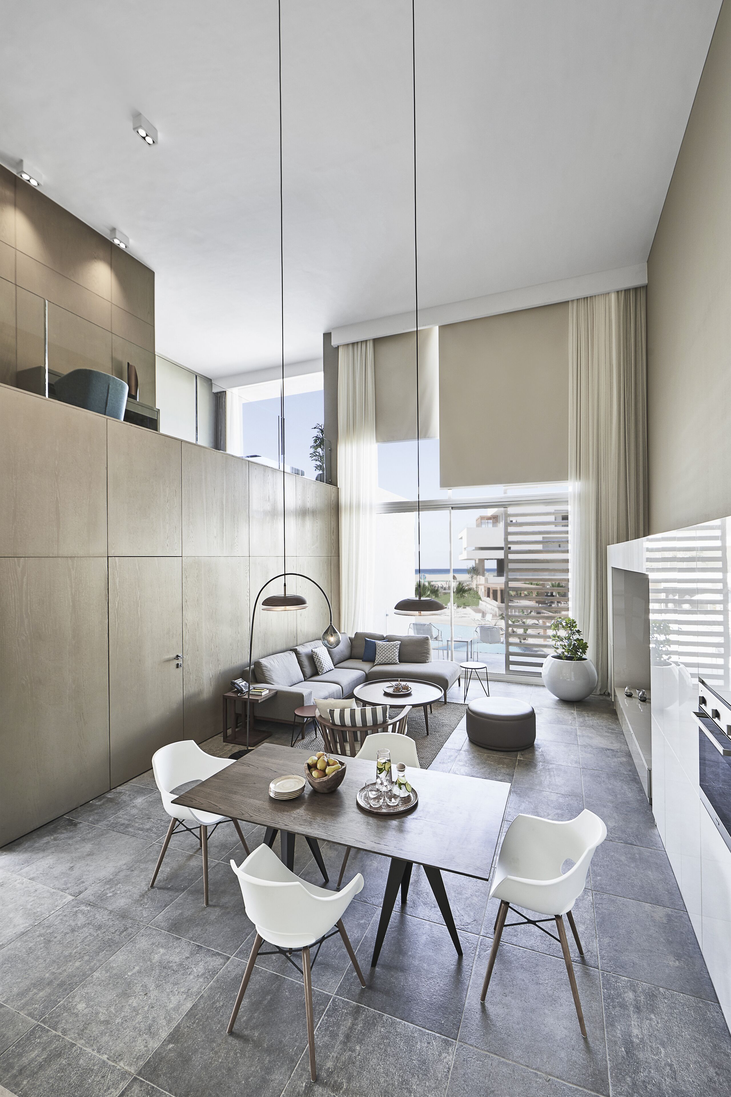 Un espacio habitable moderno con comedor, un conjunto de sofás y una cocina.