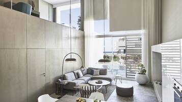 Un espacio habitable moderno con comedor, un conjunto de sofás y una cocina.