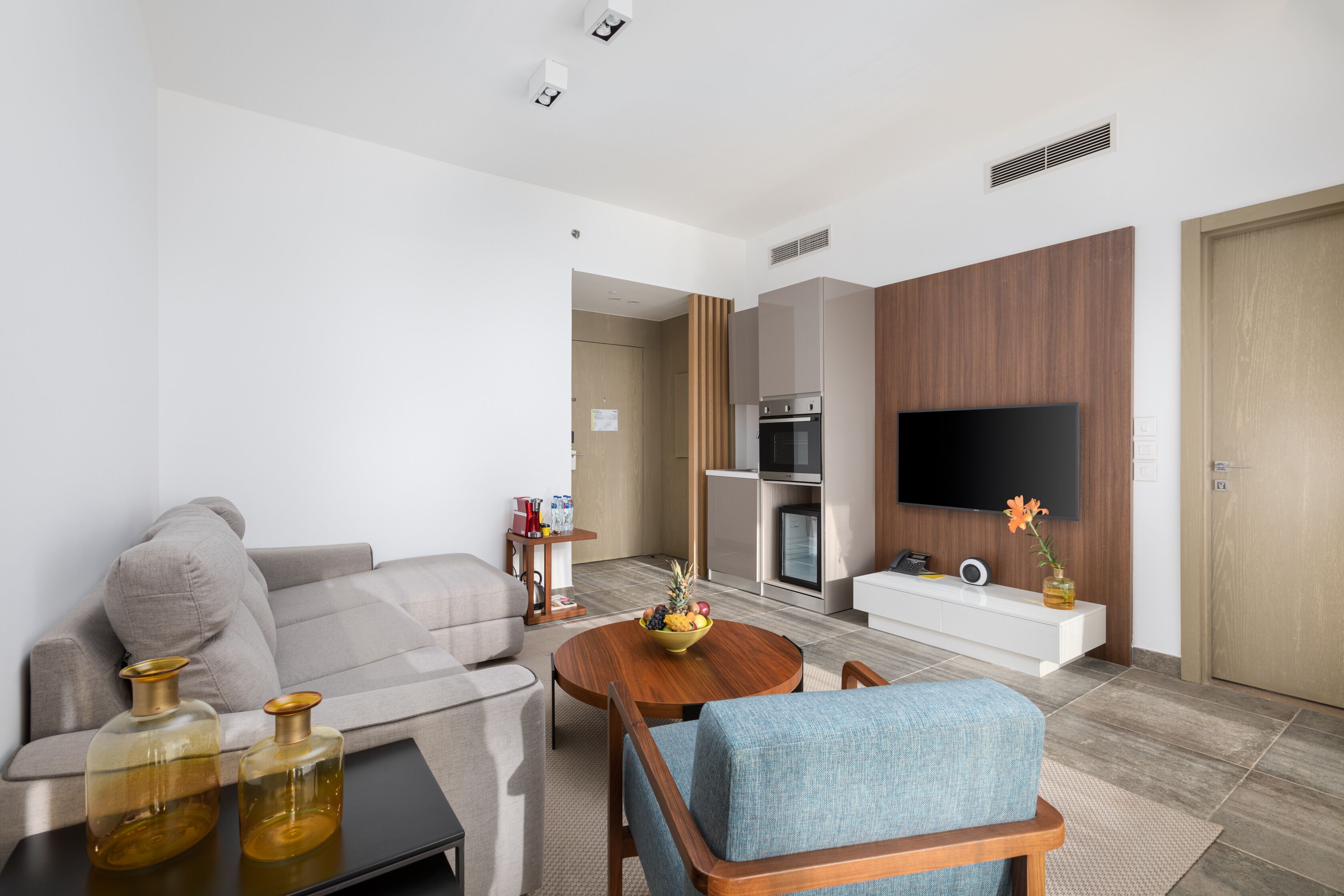 A modern living room with a sofa, a coffee table, and a TV.