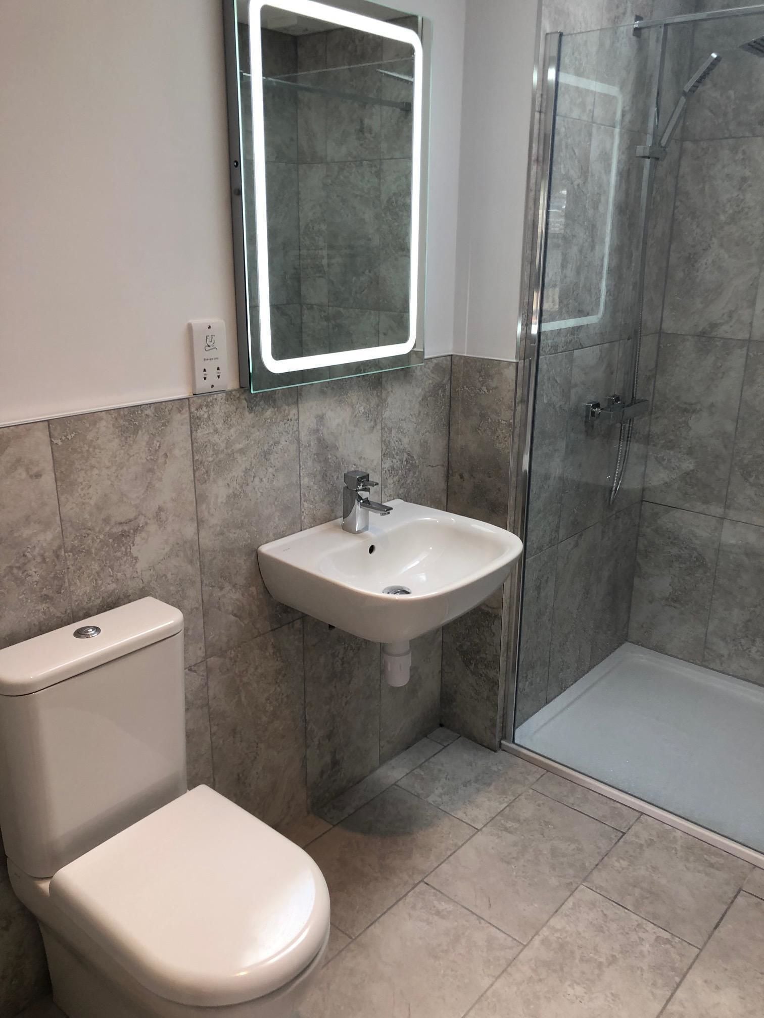 A bathroom with a toilet, a sink, and a glass-enclosed shower.