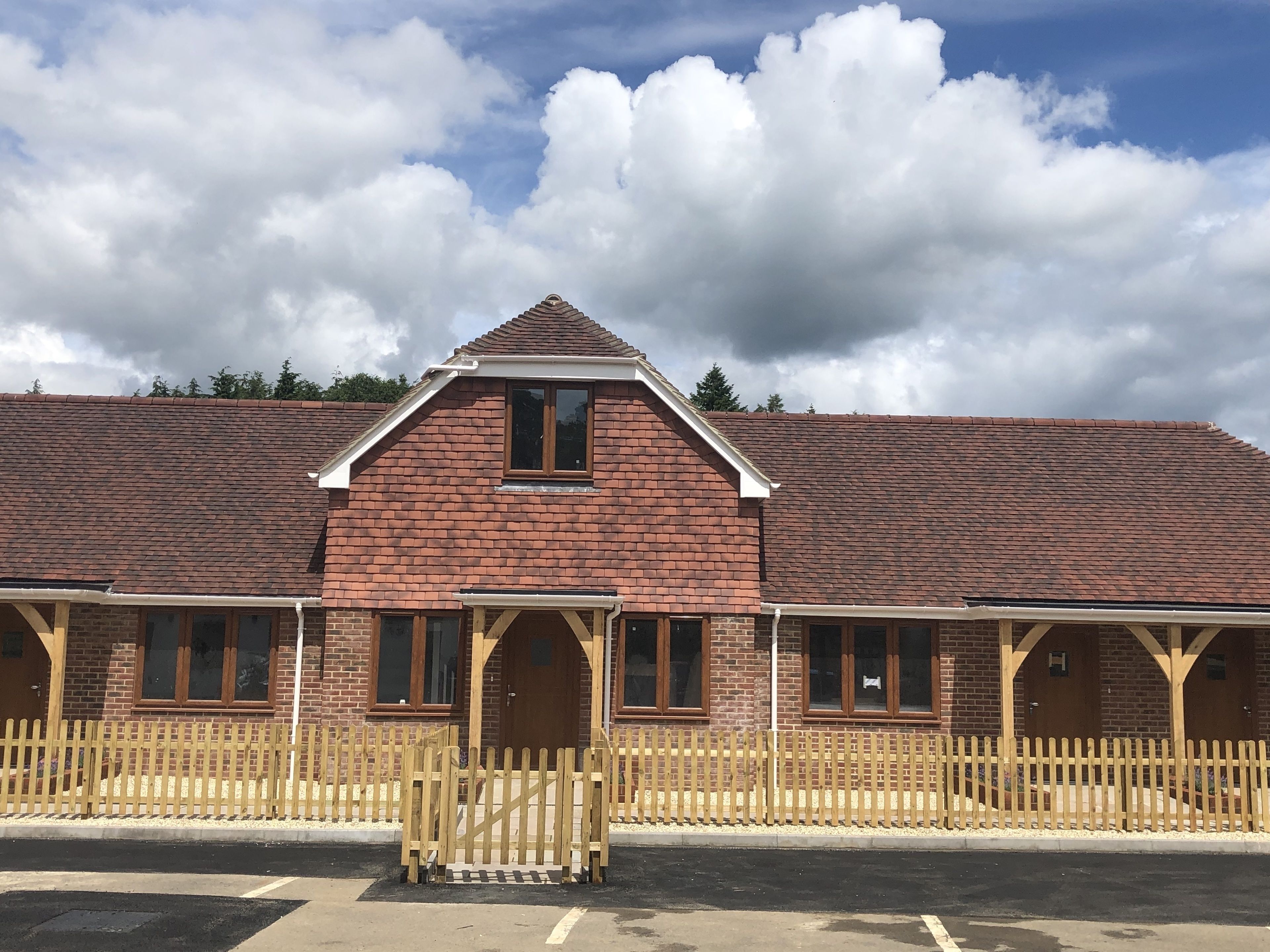 A brick building with a pitched roof and multiple windows.