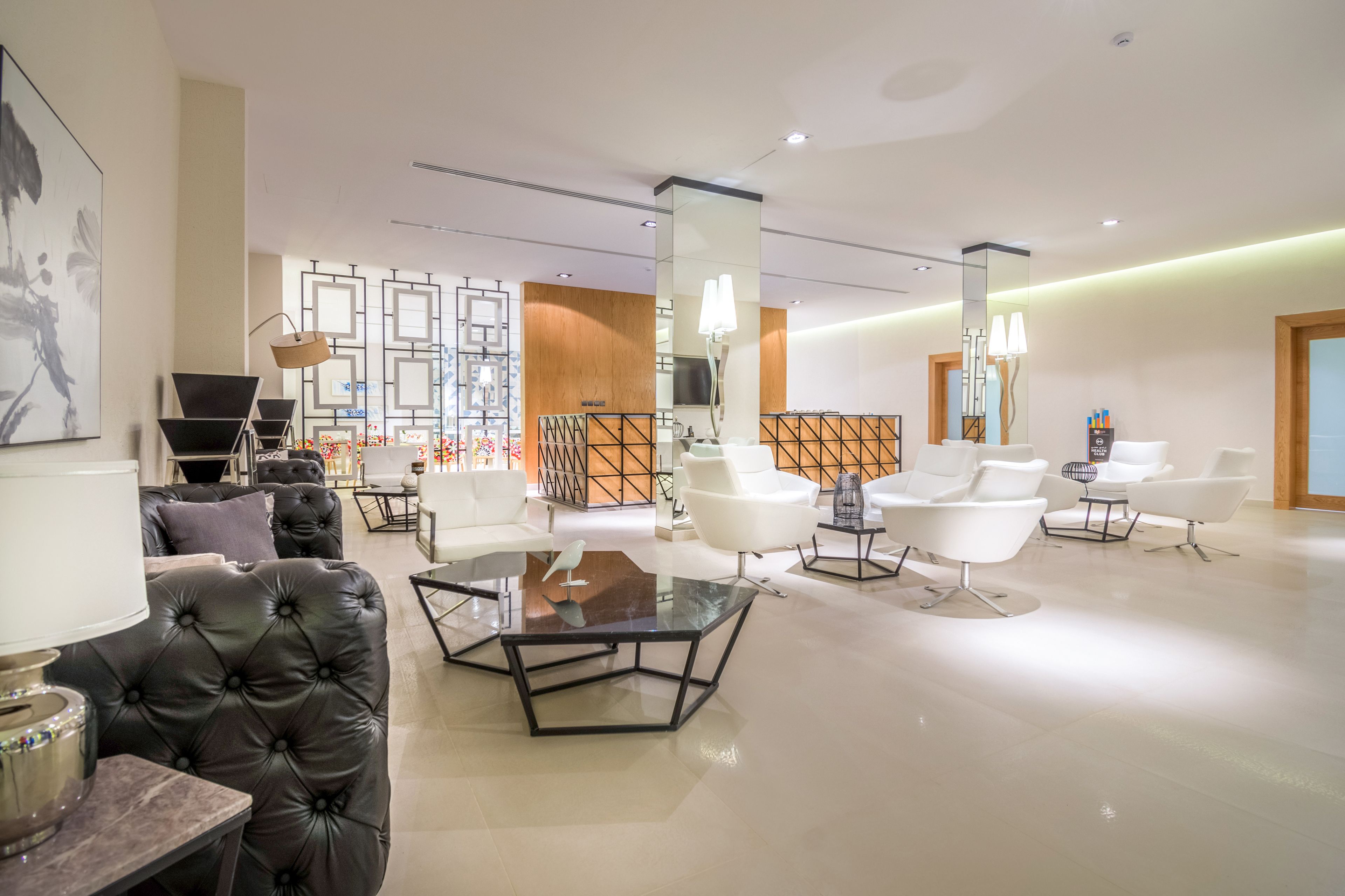 Un hall d’hôtel moderne, doté de canapés en cuir, de tables en verre et de luminaires au design contemporain.