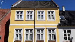 A yellow building with white window frames and a number '34' on the side.