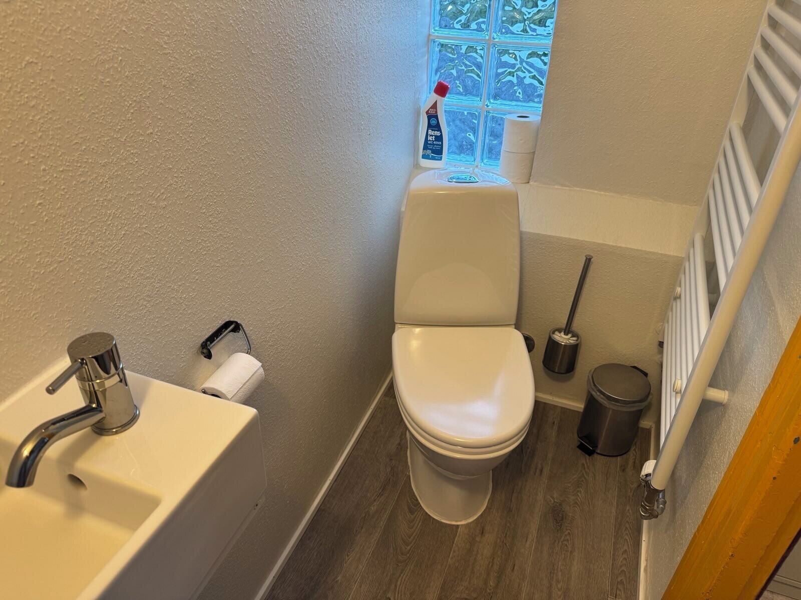 Un baño pequeño con inodoro, lavamanos y ventana.