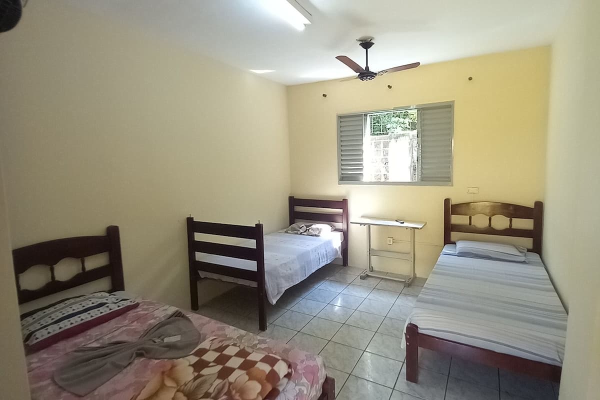 A bedroom with two single beds, a desk, and a chair.