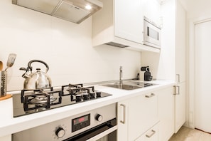 Enjoy cooking in this fully equipped kitchen with a gas stove, sink, and microwave.