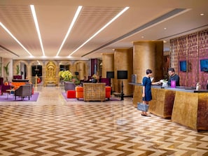 A hotel lobby with a reception desk, seating area, and decorative arches. - Grand Mercure Bengaluru at Gopalan Mall- An Accor Hotels Brand (Bengaluru)