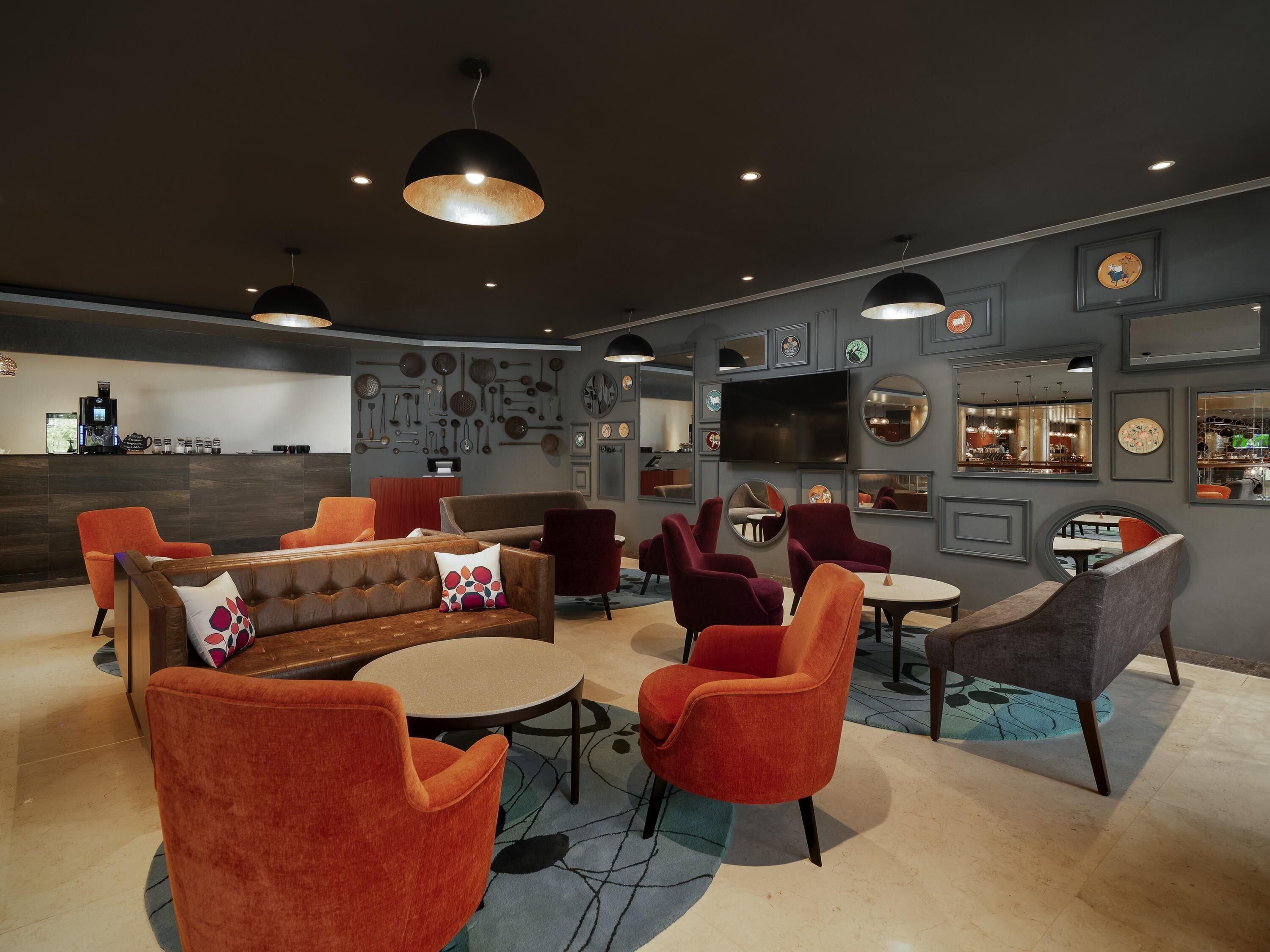 Ein moderner Lounge-Bereich mit einer Couch, Sesseln und einer Kaffeestation.