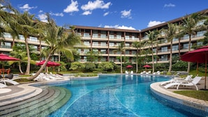 A hotel with a swimming pool, palm trees, and red umbrellas. - Wingate by Wyndham Hainan Chengmai (Chengmai)