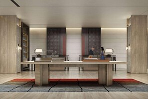 Un moderno vestíbulo de hotel con un mostrador de recepción central, dos puertas grandes con diseños y una estética minimalista.
