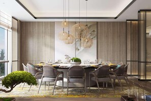 Un comedor moderno con una mesa redonda, varias sillas y una obra de arte grande en la pared.